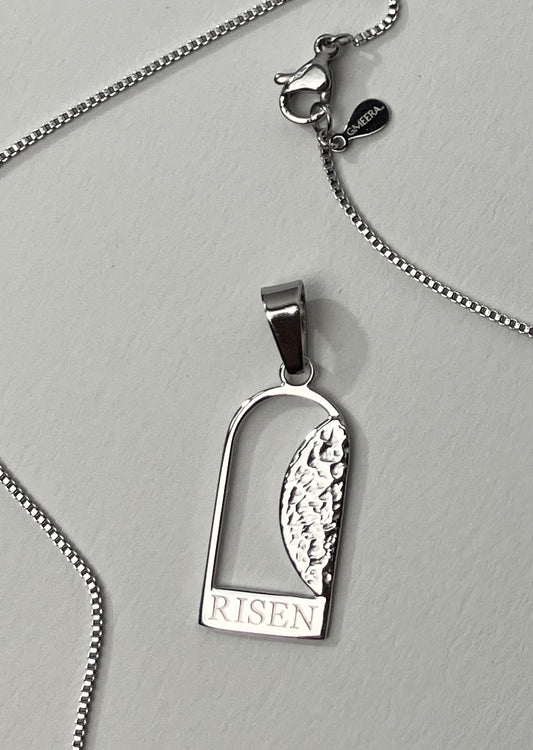 Empty Tomb pendant, stainless steel, silver color, size 12mm x 23mm H, extended base, inscribed "RISEN" font Times New Roman, textured stone. (CHAIN SOLD SEPARATELY.)