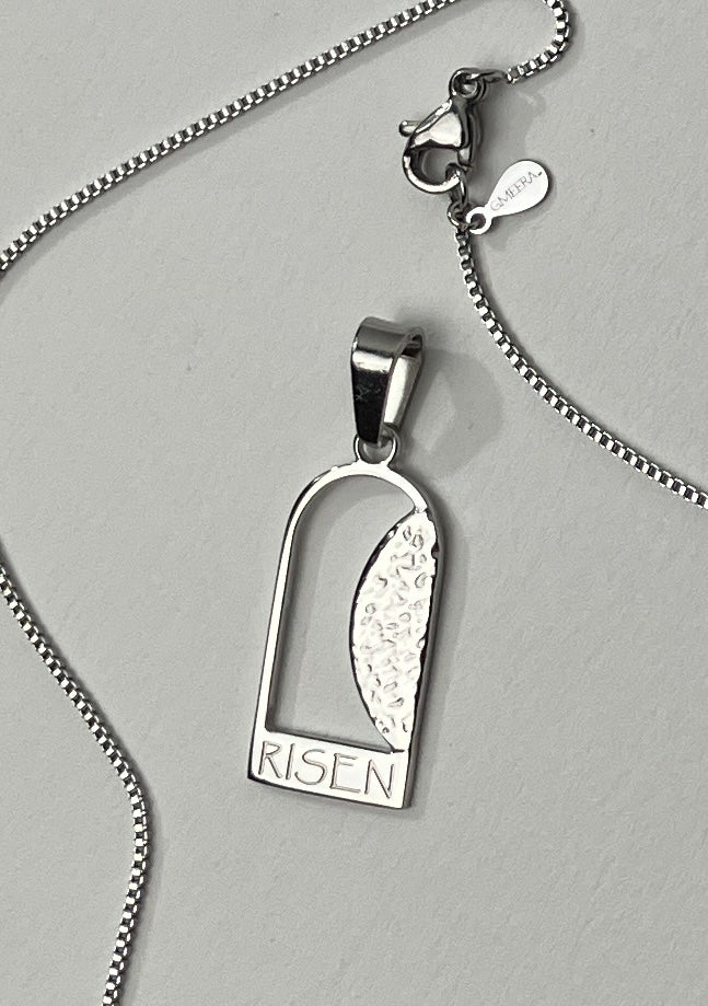 Empty Tomb pendant, stainless steel, silver color, size 12mm x 23mm H, extended base, inscribed "RISEN" font Papyrus, textured stone. (CHAIN SOLD SEPARATELY.)